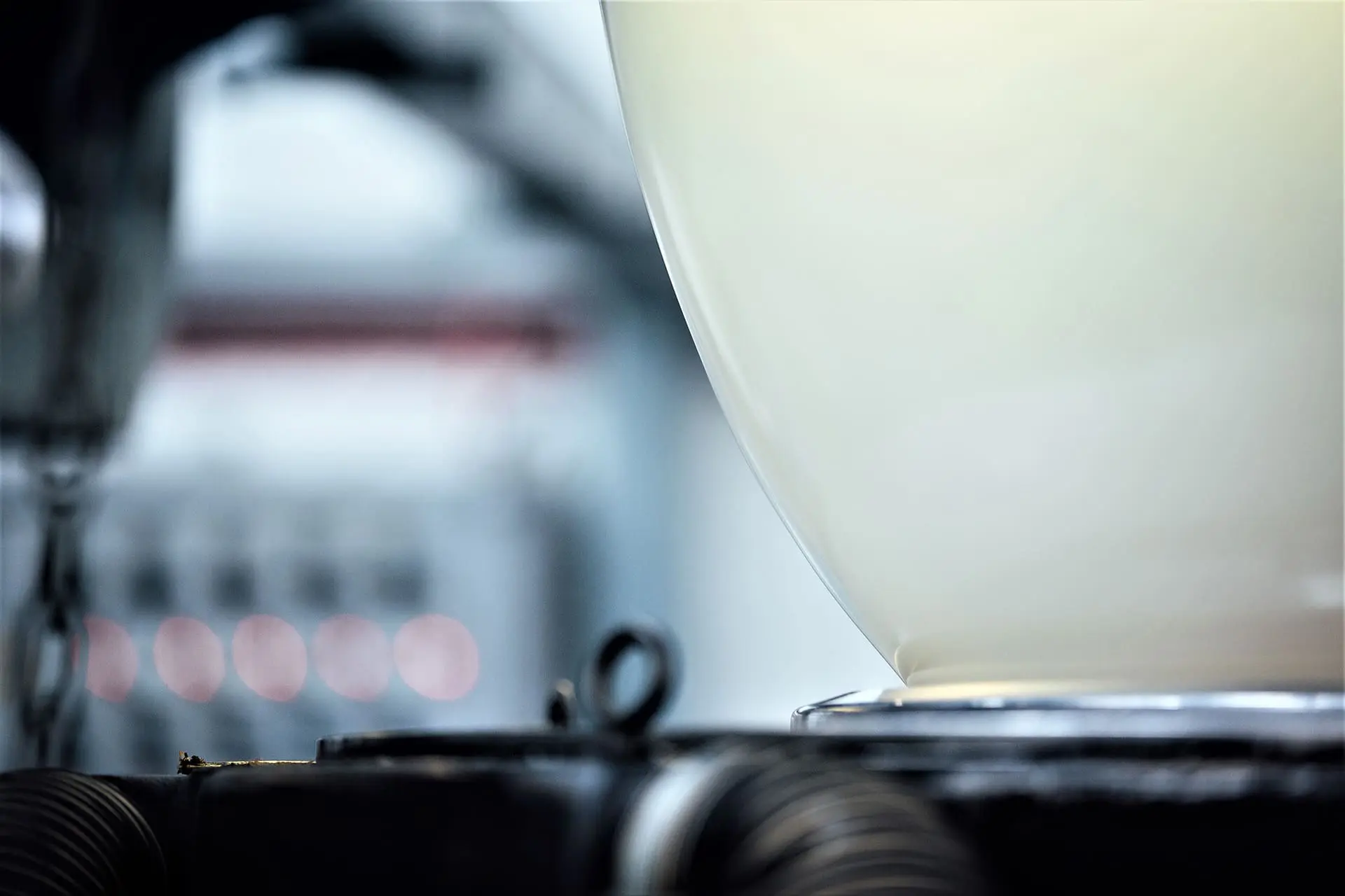 Blown-Film-Retouched Close-up of industrial machinery with a large, smooth, cream-colored surface in a factory setting.