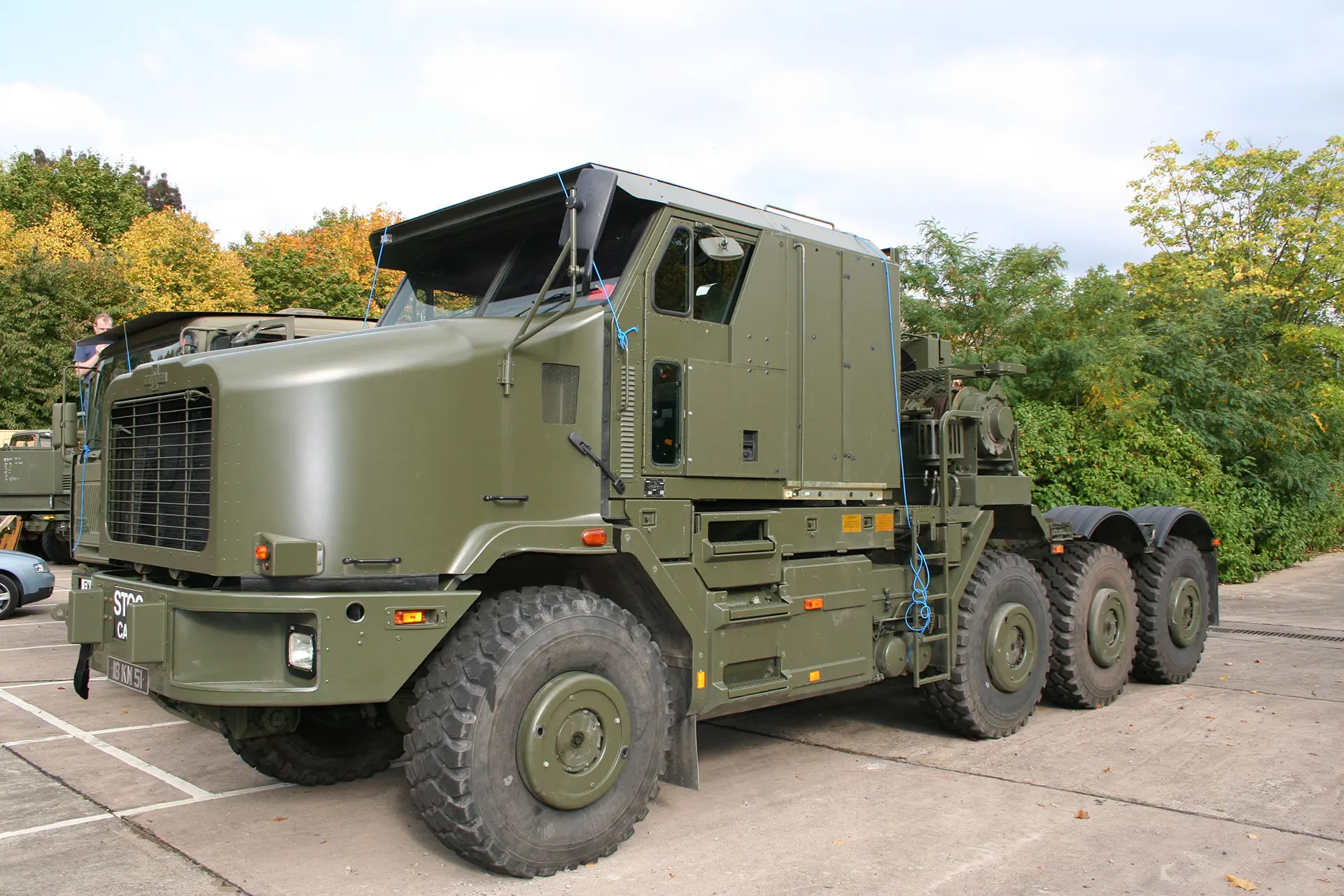 IMG_0444 A large, green military truck with eight wheels is parked on a concrete surface outdoors.