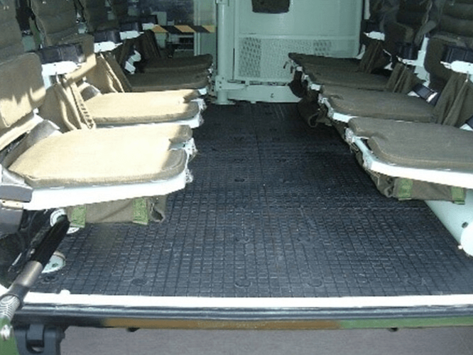 1.png-1 Interior of a military vehicle with two rows of foldable seats facing each other.