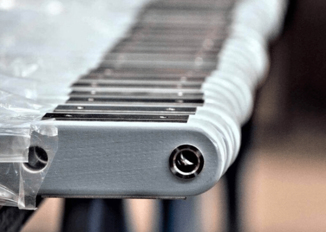 Close-up of a xylophone or glockenspiel with metal bars and a plastic covering on the left side.