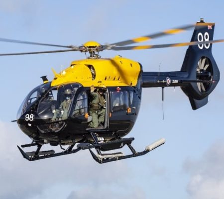Black and yellow helicopter featuring air defence composites, two crew in cockpit.