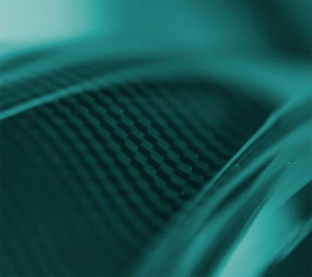 carbon Close-up of a textured carbon fibre surface, showcasing teal-toned composite materials.
